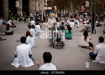 21. Oktober 2020, Barcelona, Katalonien, Spanien: In Barcelona gehen zwei Frauen mit Gesichtsmasken an einem Protest von Anwohnern der Medizin (mir) vorbei, die Verbesserungen der Arbeitsbedingungen fordern. Spanien überschreitet eine Million Fälle von Coronavirus und Regierung betrachtet einen landesweiten Alarmzustand, um eine Ausgangssperre zu implementieren. Quelle: Jordi Boixareu/Alamy Live News Stockfoto