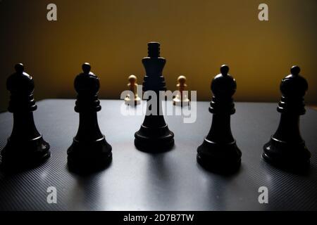 Belästigende Bewegung mehrerer schwarzer Schachfiguren gegen zwei isolierte Weiße Bauern Stockfoto