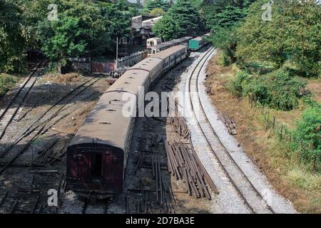 Ein lokaler alter traditioneller Personenzug für die kreisförmige Eisenbahnlinie, der noch am Bahnhof in Yangon/Rangun, Myanmar/Burma steht Stockfoto