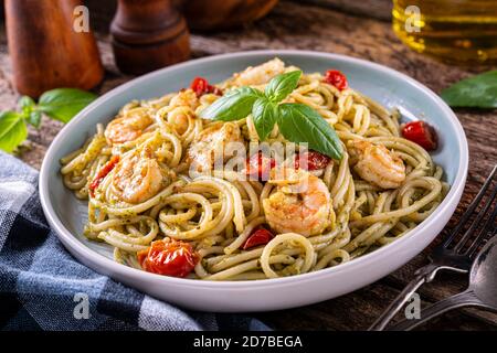 Ein Teller mit köstlichem Garnelenpesto mit Basilikum, Knoblauch, Tomate, Parmesan, Olivenöl und Spaghetti. Stockfoto