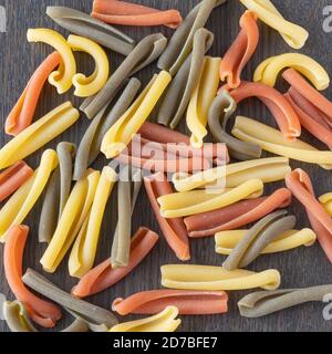 Dreifarbige Pasta, italienische Macaron in drei Farben genannt Caserecce in neutralem Hintergrund Stockfoto