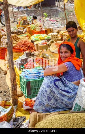 Stallhalter an einem Stand, der Chilis, Gewürze und lokale Produkte in einem Straßenmarkt in einem Dorf im Madhya Pradesh, Indien, verkauft Stockfoto