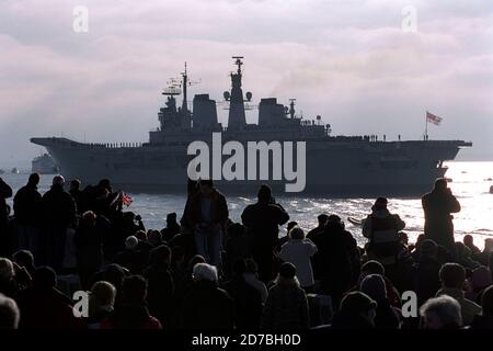 AJAXNETPHOTO. JANUAR 2003, 11. PORTSMOUTH, ENGLAND. - ARCHE BLÄTTER - (PMO5) - HMS ARK ROYAL VERLÄSST PORTSMOUTH NACH 'SOMEWHERE' ÖSTLICH VON SUEZ. TAUSENDE VON BRUNNENFLÜCHTLERN VERSAMMELTEN SICH AUF DEN ALTEN MAUERN DER STADT, UM DEN TRÄGER ZU SEHEN. FOTO: JONATHAN EASTLAND/AJAX. REF:3 13 01 5 Stockfoto