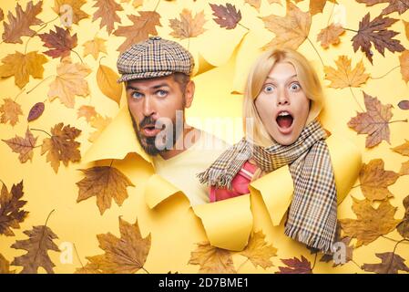 Überrascht Paar auf Herbst Kleidung Rabatte, Mann mit Bart und ein attraktives Mädchen in gelbem Hintergrund. Herbstpaar trägt im Herbst Kleidung Stockfoto