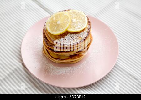 Hausgemachte Zitronen Ricotta Pfannkuchen auf einem rosa Teller, Seitenansicht. Nahaufnahme. Stockfoto