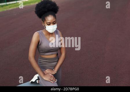 Ein junges Mädchen geht in einer Schutzmaske auf die Straße zum Sport. Sport in Quarantäne, Coronavirus, covid-19 Konzept. Stockfoto