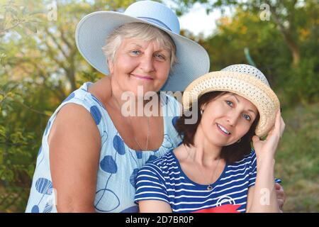 Glückliche Tochter umarmt ihre lächelnde Mutter. Stockfoto