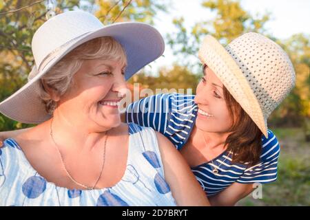 Glückliche Tochter umarmt ihre lächelnde Mutter. Stockfoto