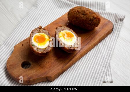 Hausgemachte Scotch Eier auf einem rustikalen Holzbrett, Seitenansicht. Stockfoto