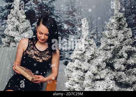 Schöne Frau mit Weihnachten an Tannen präsentieren. Stockfoto