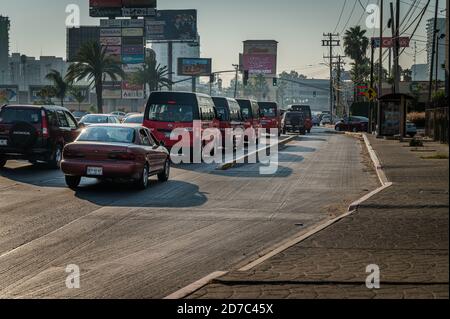 Riesige Werbetafeln auf einer belebten Straße in Tijuana, Mexiko mit Stau. Stockfoto