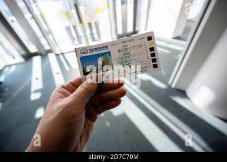 Nagoya / Japan - Nov 27 2019 : EINE Männerhand hält am Morgen ein Ticket für das Nagoya City Science Museum. Dies ist eine beliebte touristische destinatio Stockfoto