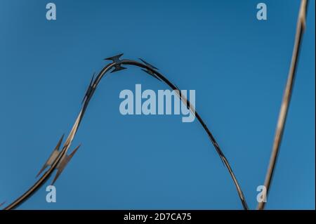 Nahaufnahme von Stacheldraht gegen blauen Himmel Stockfoto