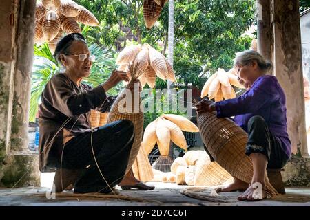 Provinz Hung Yen, Vietnam - 16. September 2020: Nicht identifizierte Frauen, die im traditionellen Dorf leben, weben Bambusstäbchen, um Bambusprodukte herzustellen. Stockfoto