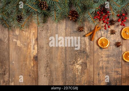 Hintergrund zum neuen Jahr. Fichtenzweige auf einem Holztisch. Ornamente für den Neujahrsbaum. Urlaub Evergreen Zweige und Beeren über rustikalen Holz Bac Stockfoto