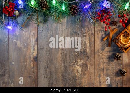Weihnachten Girlande Lichter und Dekoration auf Holzhintergrund. Weihnachtstanne mit Dekoration auf dunklem Holzbrett. Border Art Design mit Christma Stockfoto