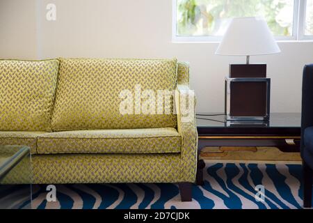 Innenarchitektur für Ihr Zuhause. Wohnzimmer mit einem gelb grünen Sofa und einer Tischlampe. Moderner, moderner, sauberer Stil. Stockfoto