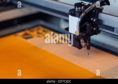 Laserschneiden. Laser Cutter Maschine und orange Acrylplatte mit geometrischen Formen geschnitten. Stockfoto