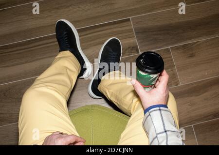 Crop man mit Kaffee zum Mitnehmen im Café Stockfoto