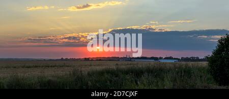 Sommer Sonnenuntergang ländliche Landschaft mit dramatischen Himmel über den Feldern. Stockfoto