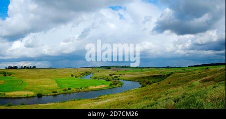 Schöne Panoramalandschaft mit Flusskurve und dunklen Sturmwolken Über das Land Stockfoto