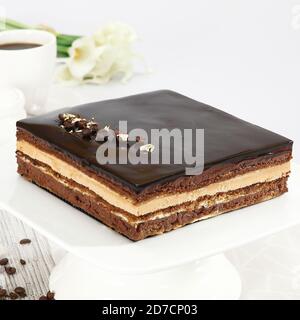 pera Cake - Opera Cake ist ein französischer Kuchen. Es wird mit Schichten von Mandelkuchen Biskuit in Kaffeesirup getränkt, mit Ganache und Kaffee geschichtet. Stockfoto