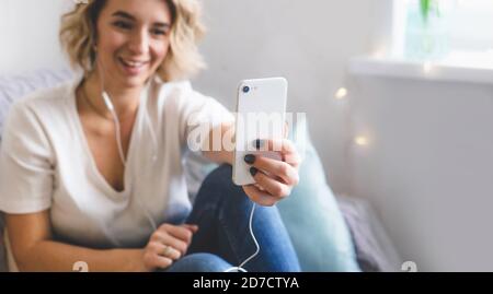 Ein junges Mädchen Blogger kommuniziert mit ihren Abonnenten sitzen an Zuhause auf der Couch in gemütlicher Atmosphäre Stockfoto