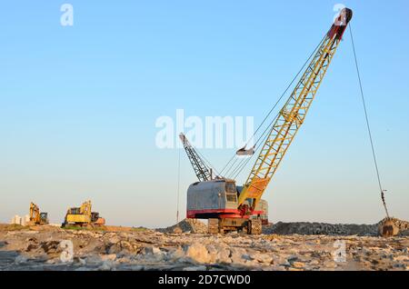 Große Raupenkran oder schleppschaufel Hydraulikbagger mit einem heavy metal Abrissbirne an einem Stahlseil. Wrecking Ball auf Baustellen. Demontage und Dm Stockfoto