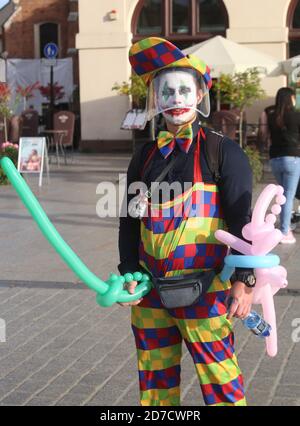 Krakau. Krakau. Polen. Zweite Welle der Coronavirus-Pandemie. Einschränkungen sind wieder da. Busker Clown trägt Kunststoff Gesichtsschutz. Stockfoto