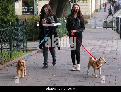 Krakau. Krakau. Polen. Zweite Welle der Coronavirus-Pandemie. Einschränkungen sind wieder da. Zwei junge Frauen gehen mit den Hunden. Stockfoto