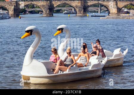 Prag Sommer Tschechische Republik Europa Frauen genießen die Flussfahrt im Schwan Tretboot Moldau in Prag Karlsbrücke zurück zum Wohlbefinden Stockfoto