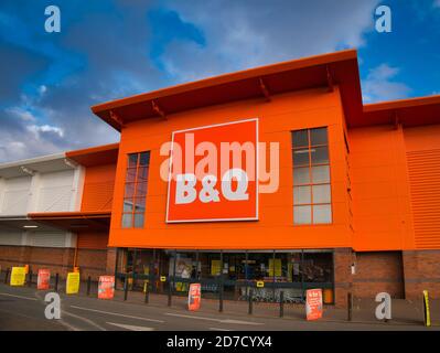 Die Fassade und das Markenlogo einer Niederlassung des britischen DIY-Stores B&Q, aufgenommen in einem lokalen Retail-Park auf Wirral, Großbritannien an einem sonnigen Nachmittag Stockfoto