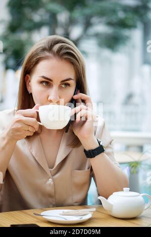 Geschäftsfrau Im Cafe Trinkt Tee. Mädchen Zuhören Sprachnachricht Bei Der Arbeit Stockfoto