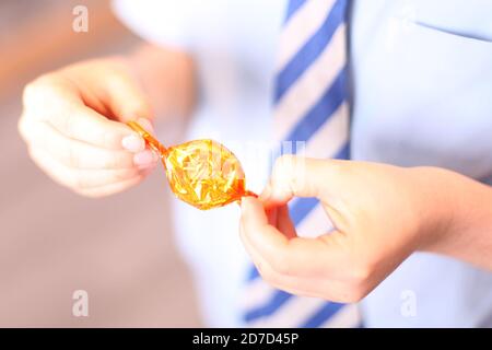 Kinder Auspacken Qualität Street Toffee Penny verpackt süß in Wrapper, close up Stockfoto