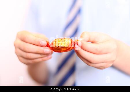 Kind Auspacken Qualität Street Orange Creme Schokolade süß in Wrapper verpackt, close up Stockfoto