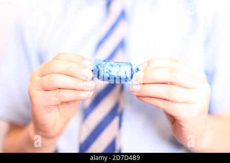 Kind Abwickeln Qualität Street Coconut Eclair Schokolade süß in Wrapper verpackt, close up Stockfoto