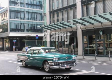 FRANKFURT AM MAIN, DEUTSCHLAND - 19. Juni 2014 : Starbucks Coffee Shop Blick und erstaunliche amerikanische Oldtimer in Frankfurt.berühmte Kaffeemarke aus USA.am Stockfoto