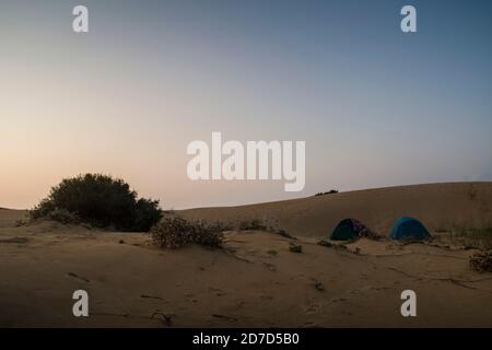 Blick auf zwei Zelten Camping in der Mitte von riesigen Sand die Dünen, am frühen Morgen mit dem Nebel aufklären Stockfoto