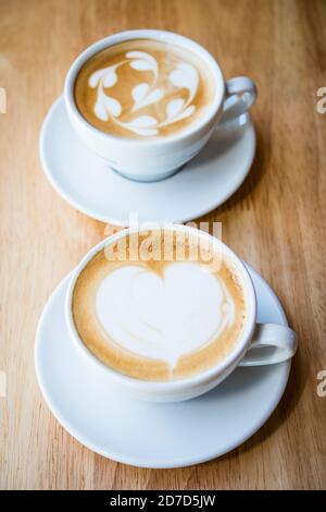 Zwei Tassen heißen Cappuccino-Kaffee mit Herzkaffee rt Oben mit Milch Stockfoto
