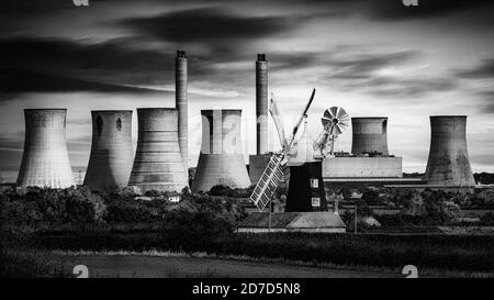 Die riesige Schranktüte des West Burton Power Station bildet den Hintergrund für eine viel ältere Form der Stromerzeugung, die Windmühle in North Leverton. Stockfoto