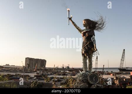 Beirut, Libanon, 17. Oktober 2020. Eine Statue einer Frau, die vom libanesischen Künstler Hayat Nazer aus zerbrochenem Glas und Trümmern der Beiruter Sprengung gemacht wurde und die "Fackel der Revolution" trug, wurde gegenüber der Sprengstelle am 4. August aufgestellt, als sich regierungsfeindliche Demonstranten in Beirut versammelten, um den Jahrestag der libanesischen Thawras zu begehen. Ein Jahr nach Beginn der Proteste am 17. Oktober 2019 Stockfoto