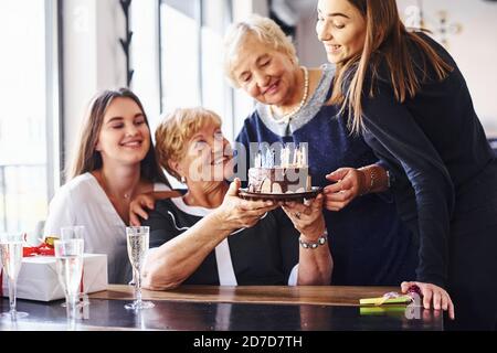 Ältere Frau mit Familie und Freunden feiern einen Geburtstag im Haus Stockfoto