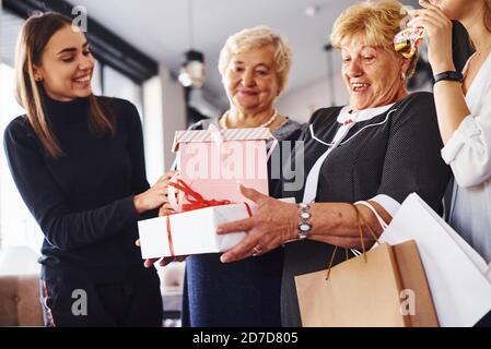 Ältere Frau mit Familie und Freunden feiern einen Geburtstag im Haus Stockfoto