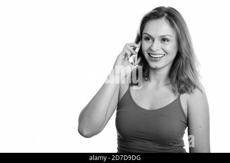 Junge glücklich brasilianische Frau lächelnd während Gespräch am Handy und Denken Stockfoto