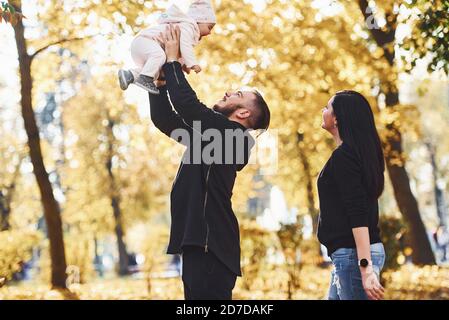 Fröhliche Familie Spaß zusammen mit ihrem Kind in schön Herbstpark Stockfoto