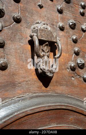 Italien, Lombardei, Rusty Türklopfer auf einem hölzernen Tor. Stockfoto