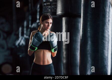 Junge Frau in sportlicher Kleidung ist in der Turnhalle mit Trainingstag. Konzeption des Boxens Stockfoto