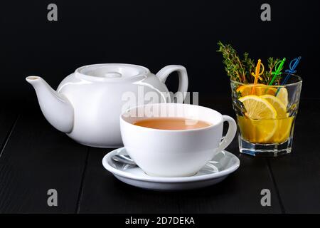 Keramik-Teekanne und Tasse mit Echinocea-Tee auf dunkel Hintergrund Stockfoto