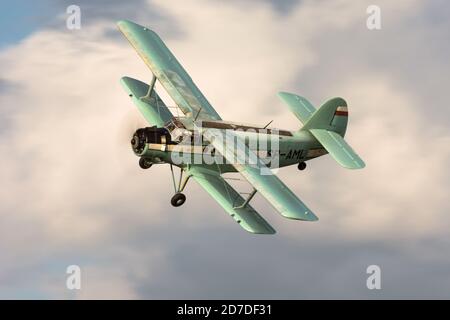 Sowjetisches Flugzeug Antonov an-2 fliegt mit Wolken im Hintergrund Stockfoto