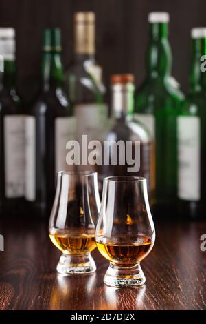 Flaschen und Glas Whisky-Spirituosen Brandy auf dunkelbraunem Hintergrund Stockfoto